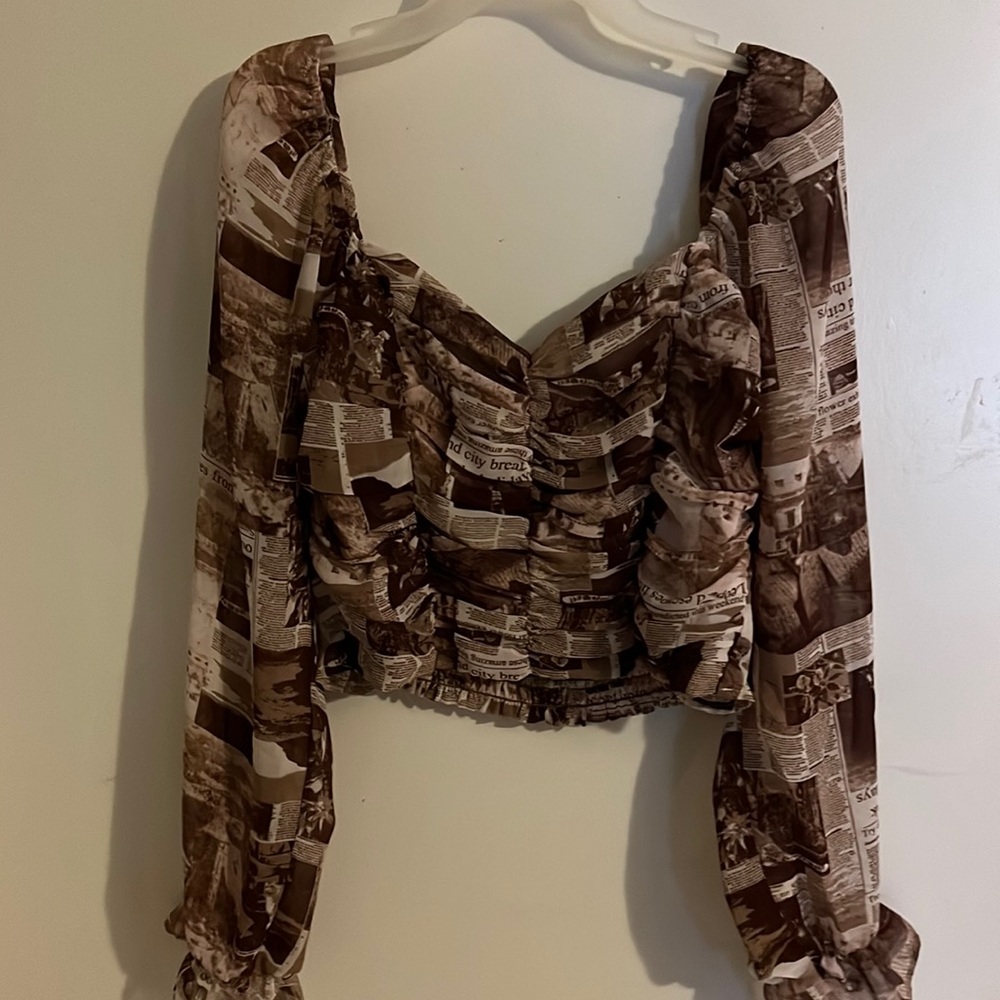 This is a blouse that has never been worn. It’s brown, tan, and cream color.